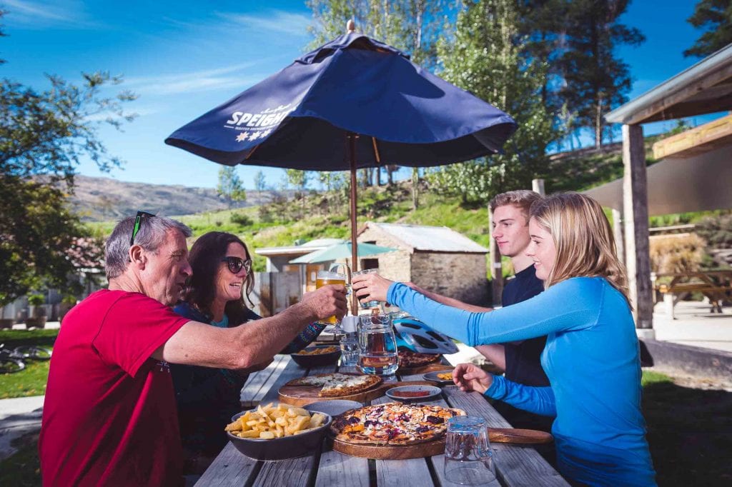 Riders enjoying beer and pizza at the Gibbston Tavern