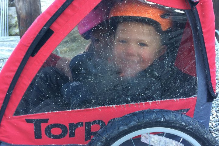 Kids loving the warm trailer on a winter bike tour.